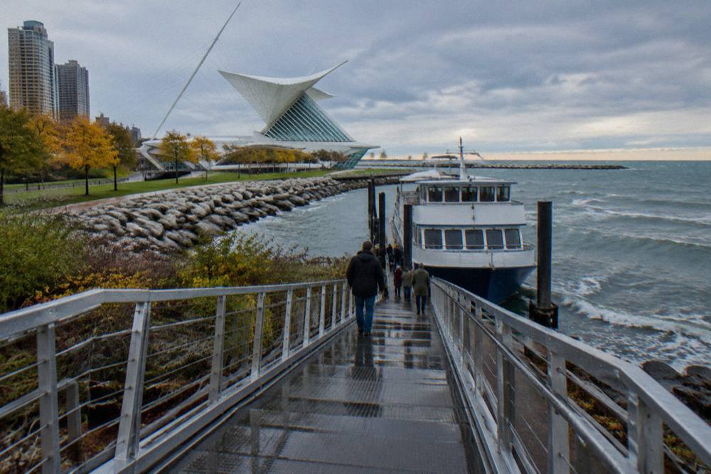 A gangway ramp leading from a downtown Milwaukee dock down to a moored passenger boat