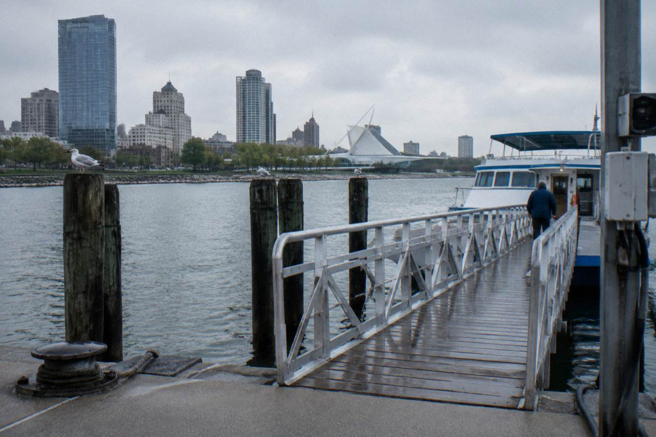 A dock on the Milwaukee River with a boarding ramp leading to a moored boat