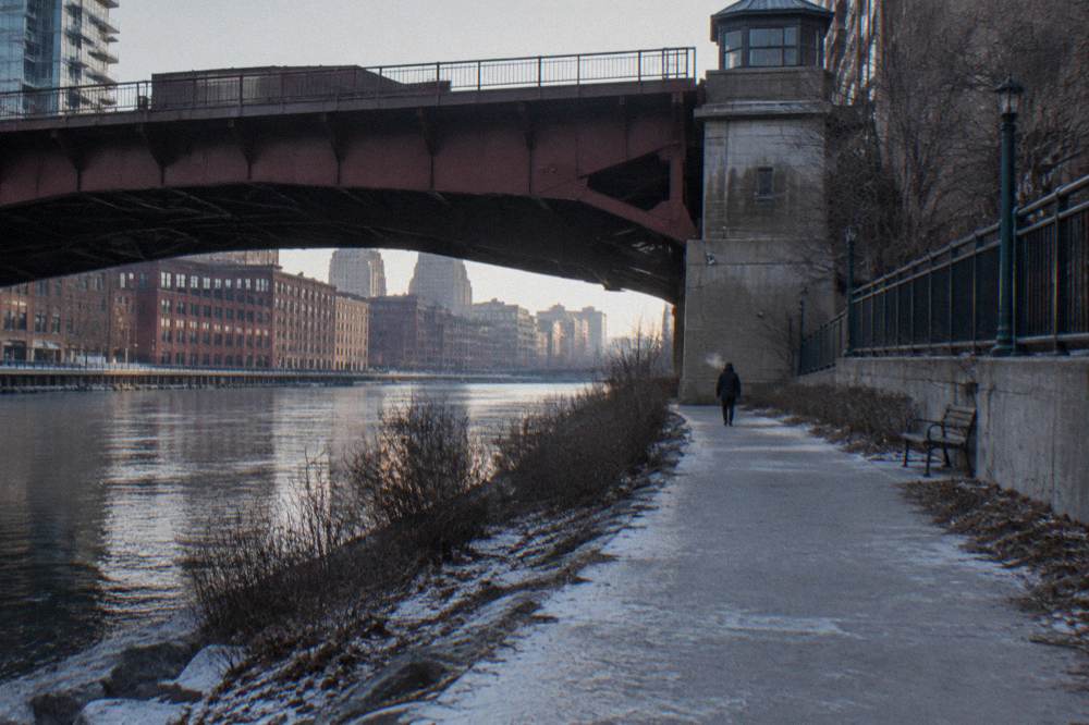 The Milwaukee Riverwalk passing beneath a downtown bridge with the river alongside