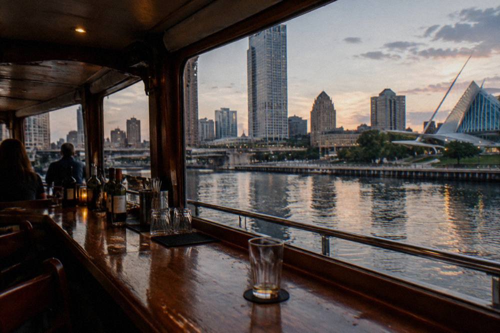 A boat bar counter with glasses and bottles arranged along a cabin window