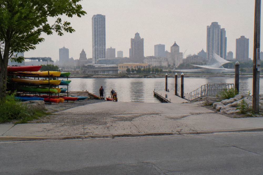 A public dock and launch area on the Milwaukee River with the downtown skyline behind it