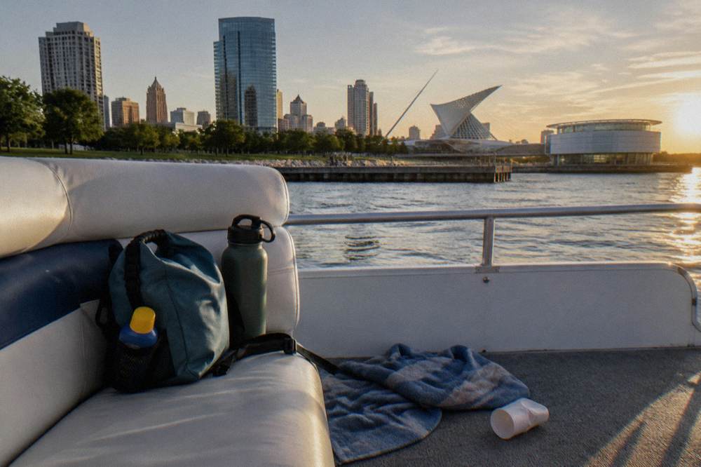 A small dry bag with sunscreen and a water bottle on a boat seat