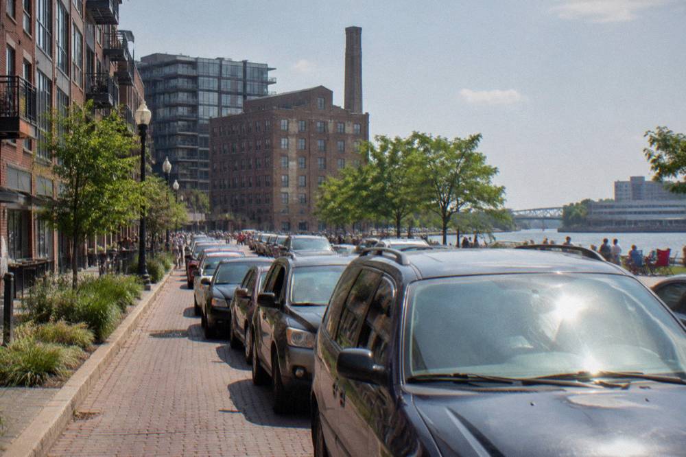 Crowded downtown Milwaukee street with cars and festival signage near the river