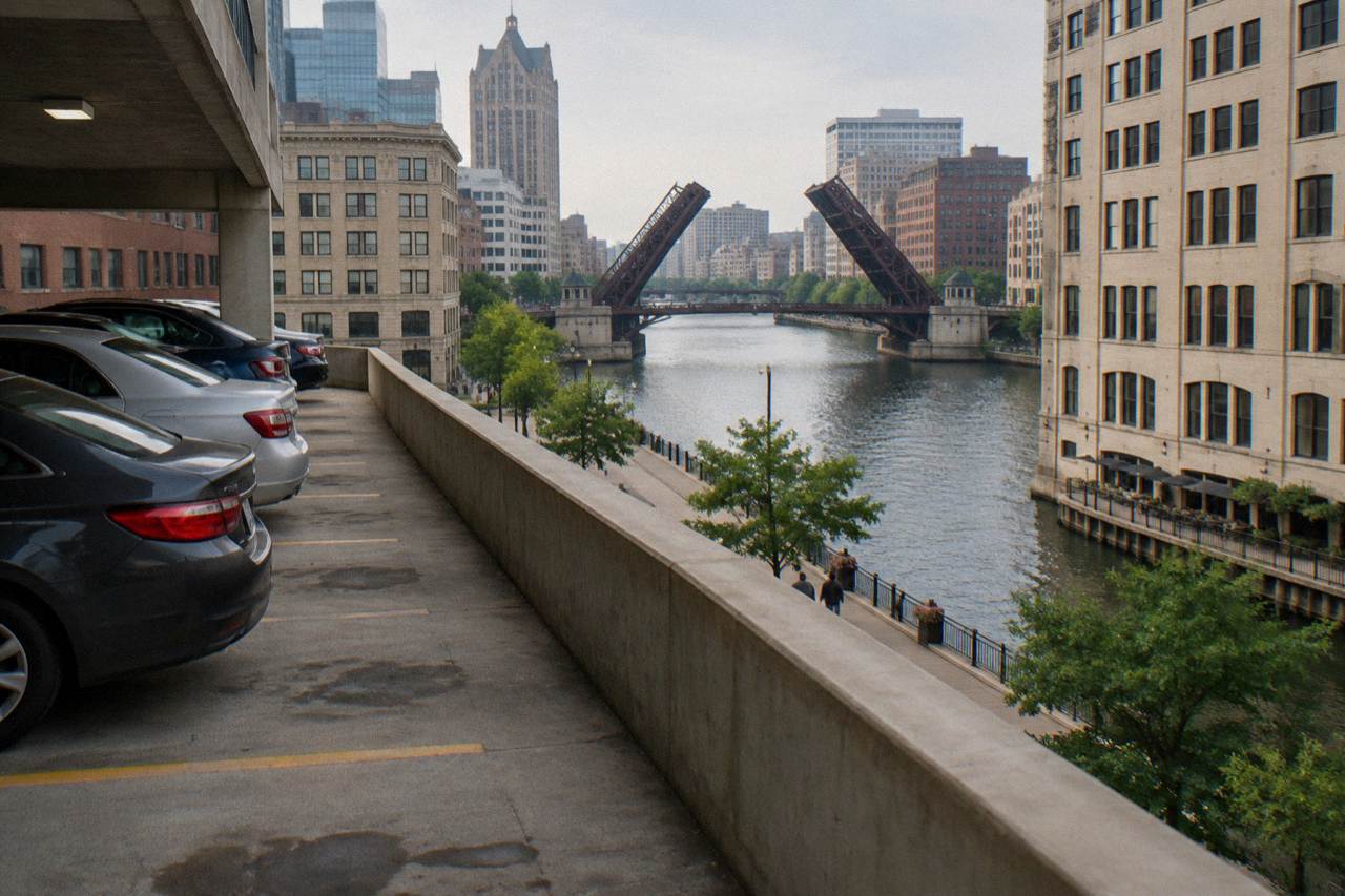 Downtown Milwaukee street with parked cars and the river in the background