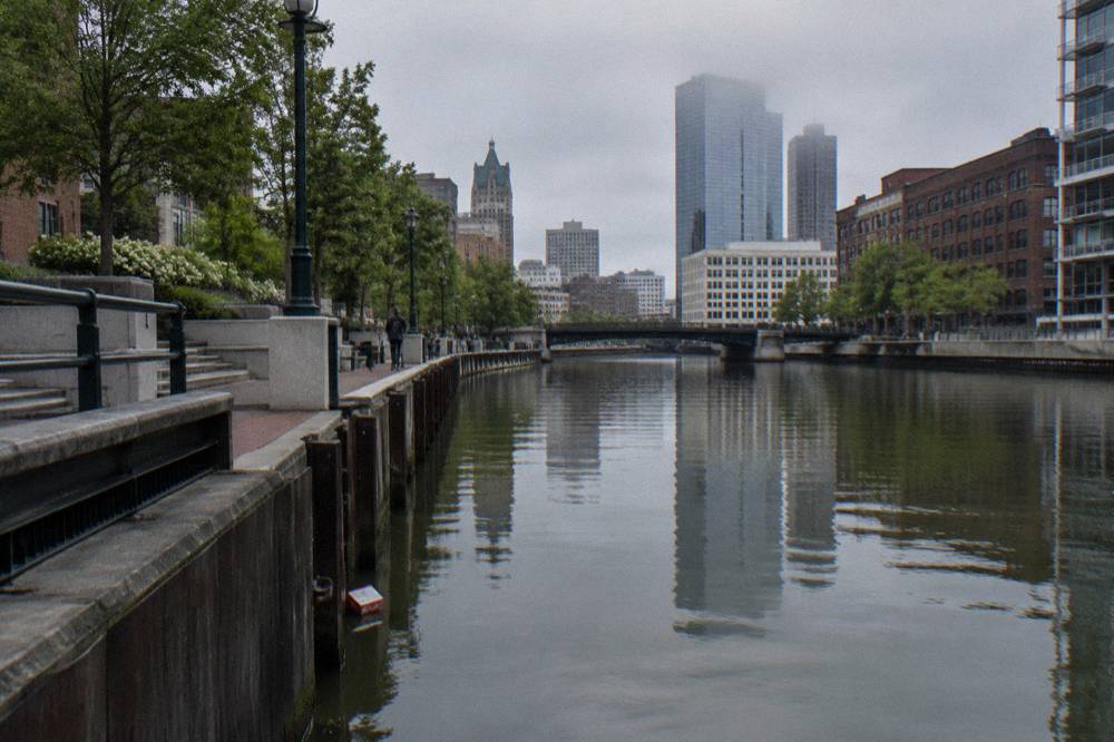 Downtown Milwaukee buildings reflected in the calm Milwaukee River near the Riverwalk