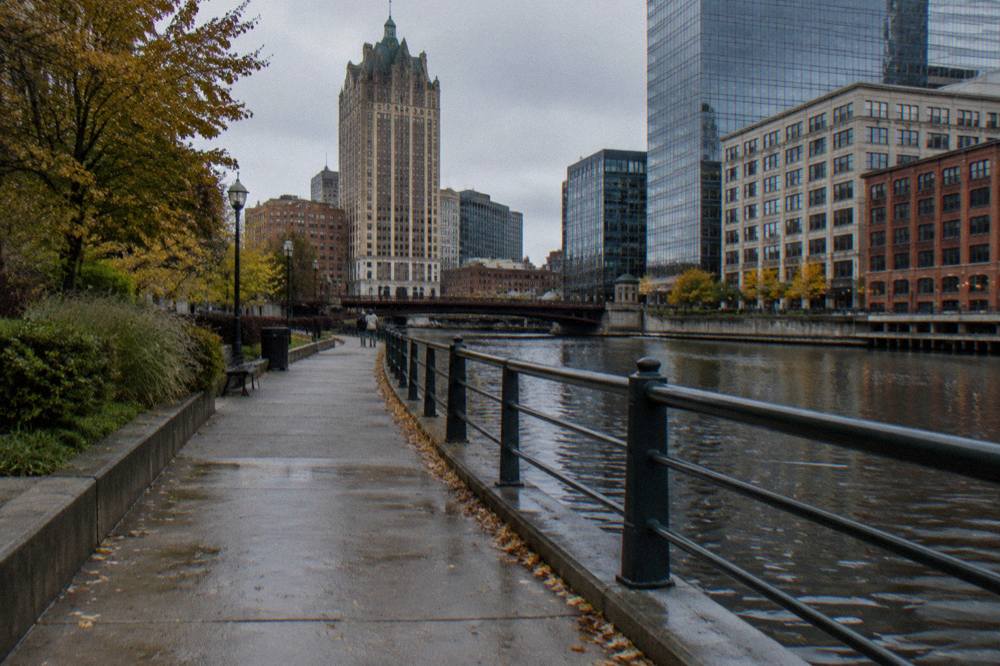 Riverwalk path beside the Milwaukee River with downtown buildings