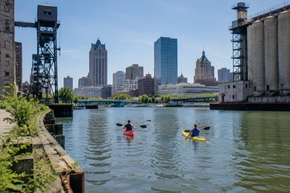 Kayaks on the Milwaukee River with the downtown skyline behind