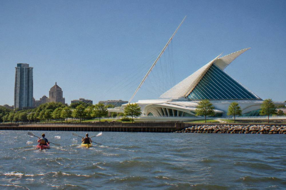 Kayaks floating on the Milwaukee River beside downtown buildings and a bascule bridge